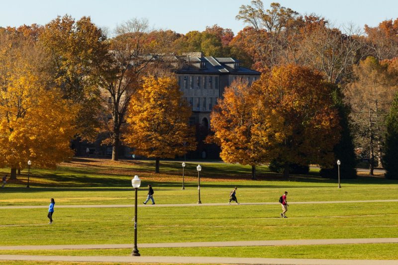 Students cross the Drillfield on clear fall day. 