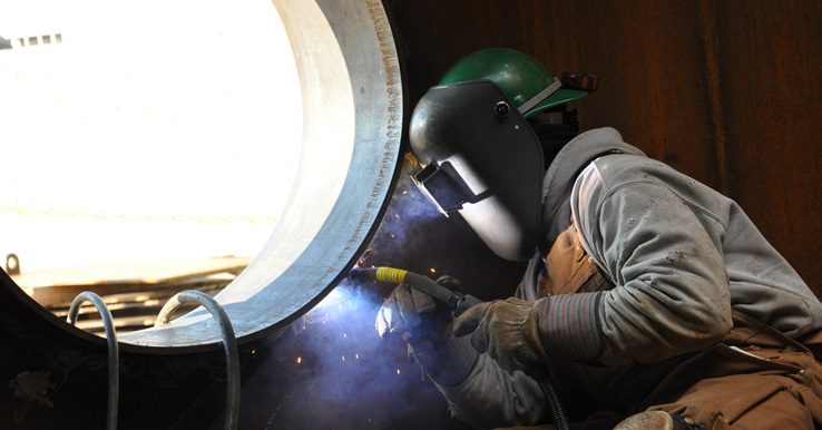 Man welding in tank