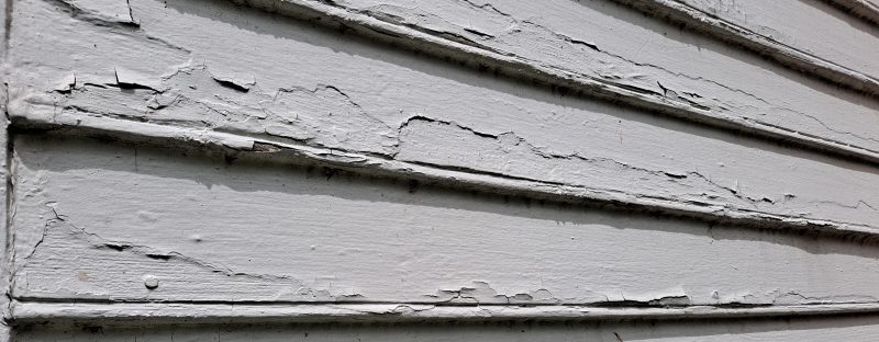 Chipped gray paint on the side of a barn